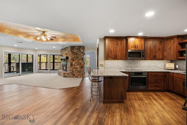 kitchen featuring stainless steel appliances, a ceiling fan, open floor plan, decorative backsplash, and open shelves