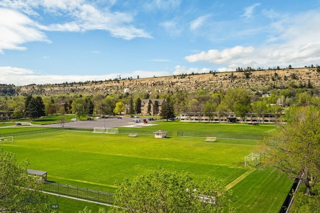 view of home's community with a sport area and view of scattered trees