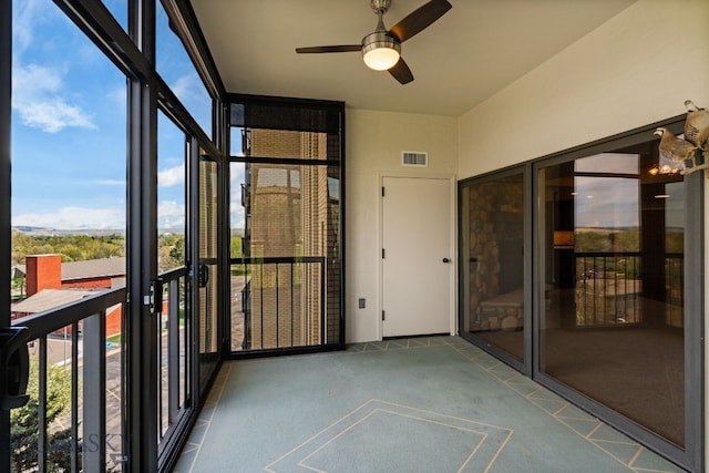 unfurnished sunroom with a ceiling fan