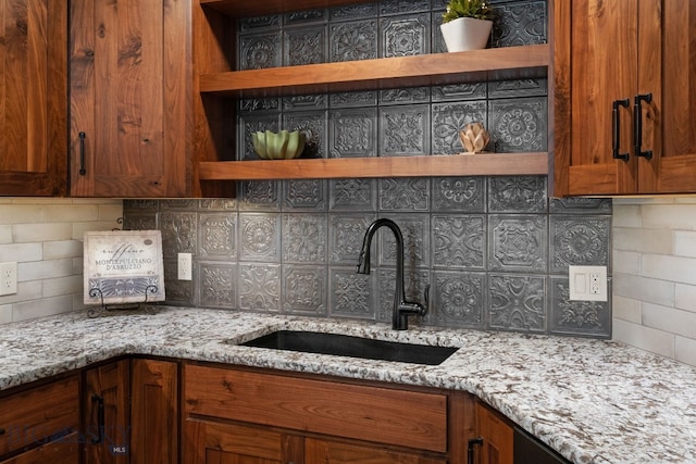 kitchen featuring open shelves, a sink, and tasteful backsplash