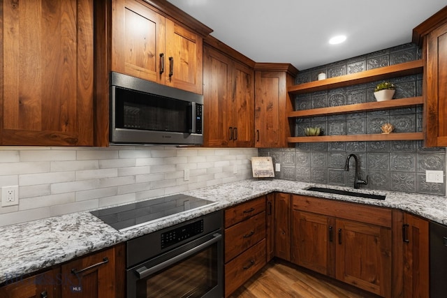 kitchen with oven, stainless steel microwave, a sink, black electric stovetop, and open shelves