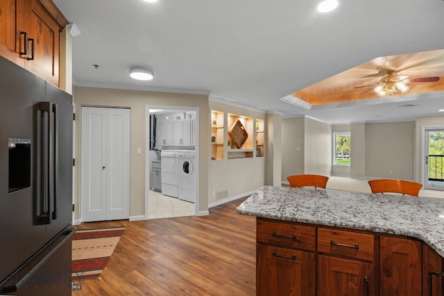 kitchen with high end fridge, separate washer and dryer, light wood finished floors, ornamental molding, and a ceiling fan