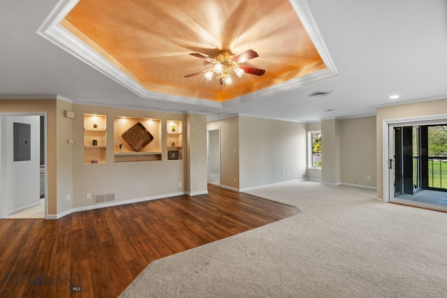 unfurnished living room featuring a tray ceiling, healthy amount of natural light, crown molding, baseboards, and recessed lighting