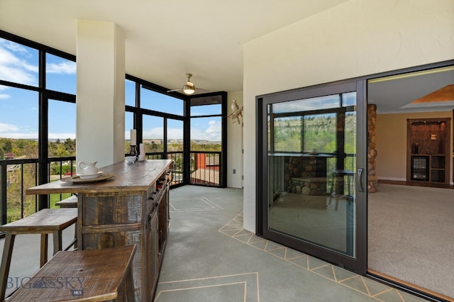 sunroom / solarium featuring carpet floors, plenty of natural light, and expansive windows