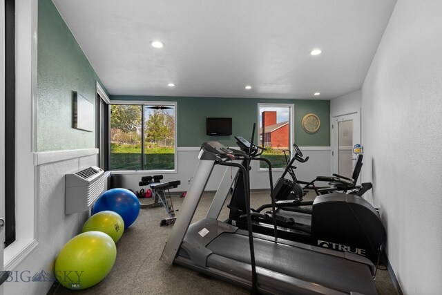 exercise area featuring recessed lighting, healthy amount of natural light, and a textured wall