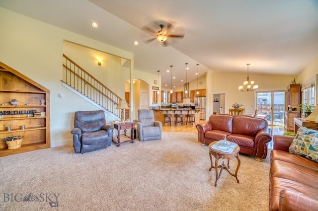 72 River Woods Rd, Belgrade, MT 59714 - living area with lofted ceiling, a chandelier, a ceiling fan, light carpet, and stairway