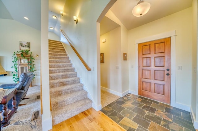 72 River Woods Rd, Belgrade, MT 59714 - foyer entrance with arched walkways, baseboards, stairs, lofted ceiling, and stone finish flooring
