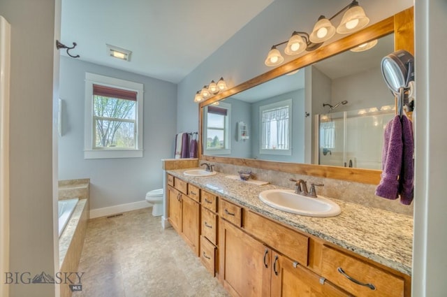 72 River Woods Rd, Belgrade, MT 59714 - full bath featuring an enclosed shower, baseboards, double vanity, toilet, and a tub to relax in