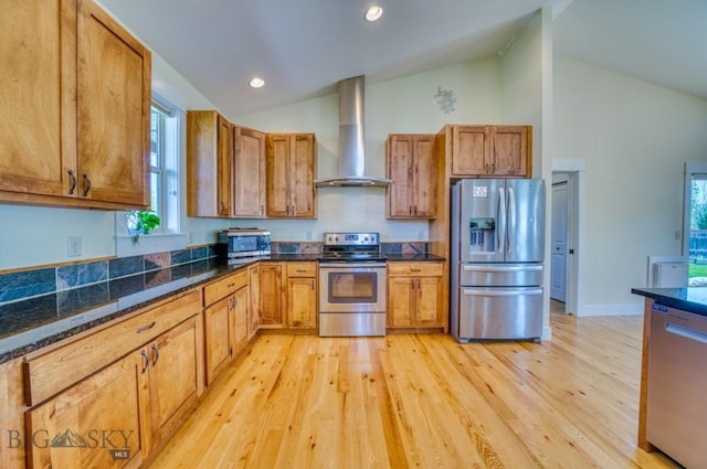 72 River Woods Rd, Belgrade, MT 59714 - kitchen with appliances with stainless steel finishes, wall chimney range hood, light wood-type flooring, brown cabinetry, and recessed lighting