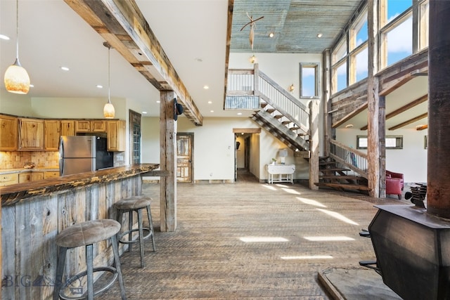 kitchen featuring freestanding refrigerator, a high ceiling, carpet flooring, recessed lighting, and decorative light fixtures