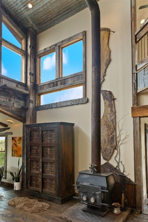 living room with a wood stove, a high ceiling, and wood finished floors