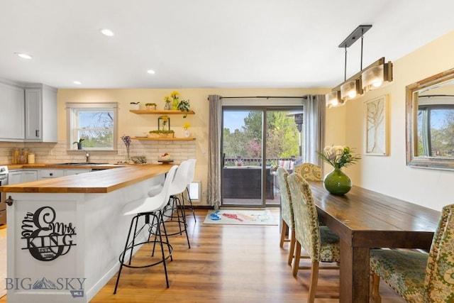 dining area featuring light wood-style flooring, healthy amount of natural light, and recessed lighting