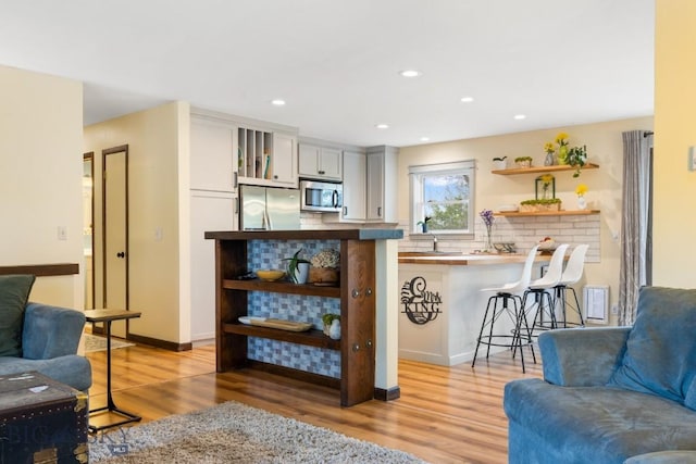 living area with light wood finished floors and recessed lighting
