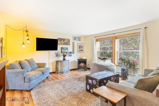 living room with wood finished floors and a wood stove