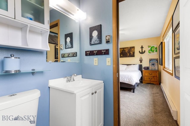 bathroom featuring a baseboard radiator, toilet, vanity, and ensuite bath