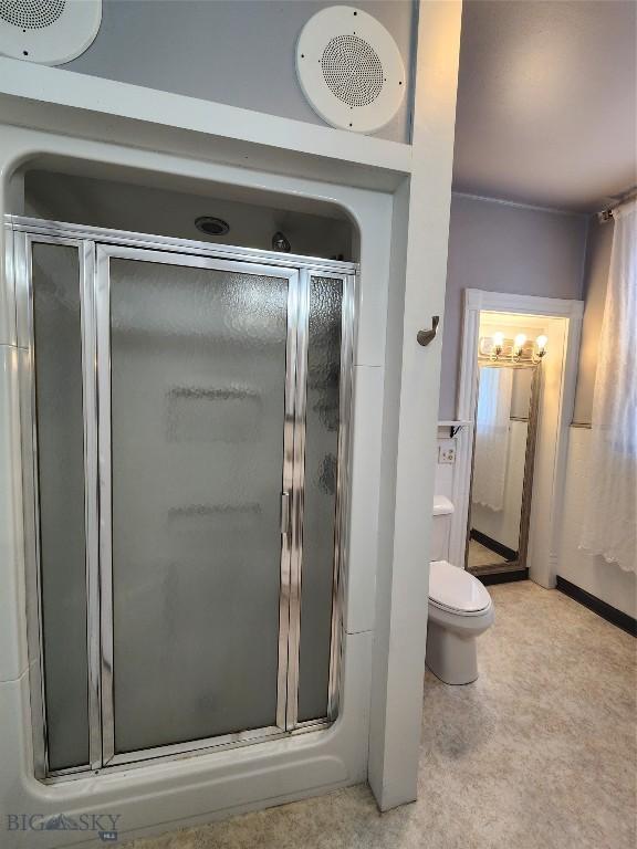 bathroom with a shower stall and toilet