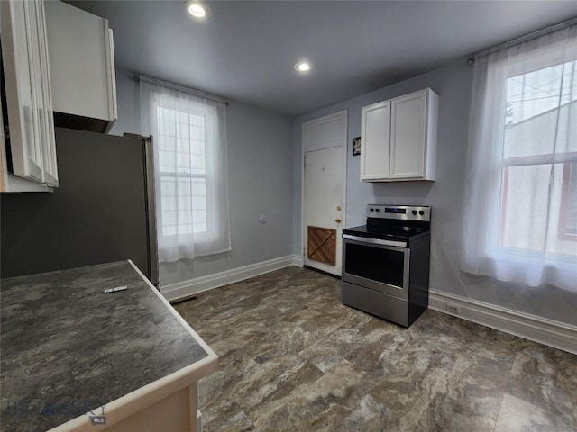 kitchen featuring stainless steel appliances, baseboards, white cabinets, and recessed lighting