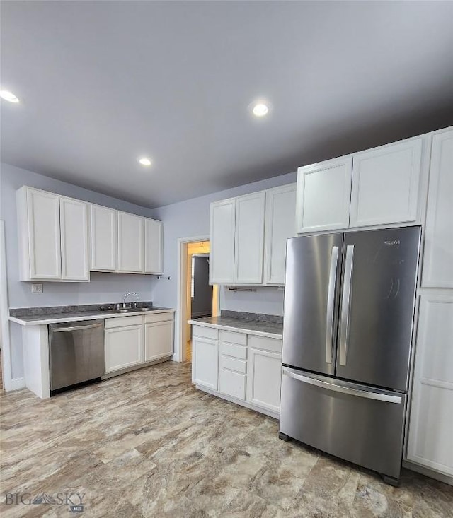 kitchen featuring appliances with stainless steel finishes, white cabinets, recessed lighting, and a sink