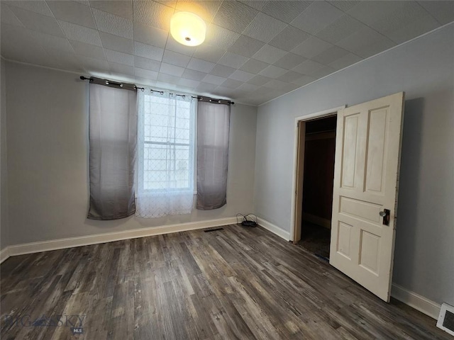 empty room with baseboards and wood finished floors