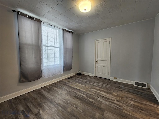 unfurnished room with dark wood-type flooring and baseboards