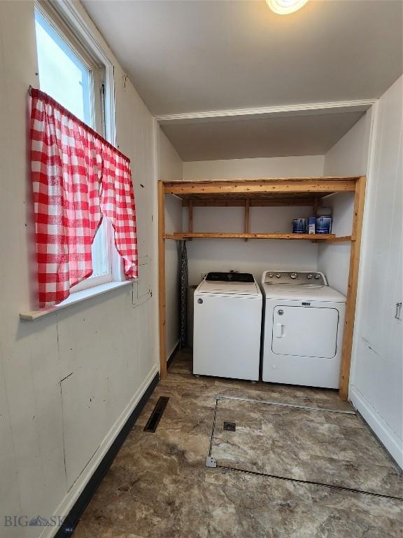 laundry area with separate washer and dryer, plenty of natural light, and baseboards
