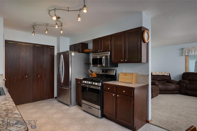 115 8th, Belgrade, MT 59714 - kitchen featuring stainless steel appliances, light countertops, dark brown cabinetry, and open floor plan