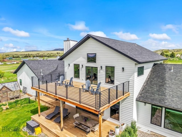200 Miller Point Pl, Belgrade, MT 59714 - rear view of property with roof with shingles, a deck, a chimney, and outdoor dining space