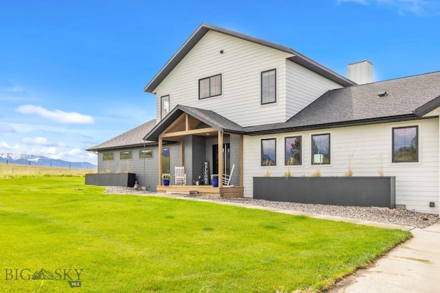 200 Miller Point Pl, Belgrade, MT 59714 - rear view of property with a yard, a mountain view, a shingled roof, and a chimney