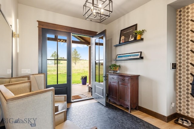 200 Miller Point Pl, Belgrade, MT 59714 - doorway featuring a chandelier, baseboards, and wood finished floors