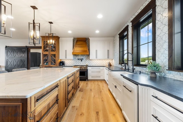 200 Miller Point Pl, Belgrade, MT 59714 - kitchen featuring premium range hood, stainless steel stove, tasteful backsplash, white cabinets, and recessed lighting