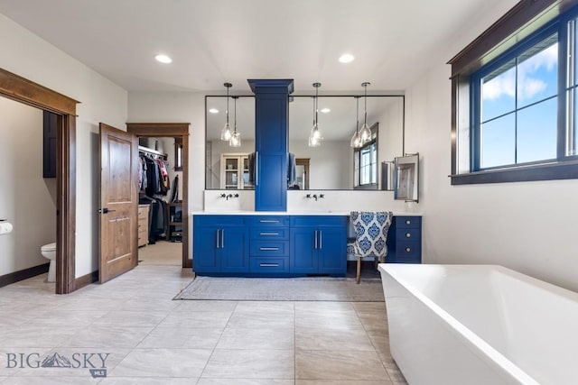 200 Miller Point Pl, Belgrade, MT 59714 - full bathroom with toilet, a freestanding tub, double vanity, recessed lighting, and a walk in closet