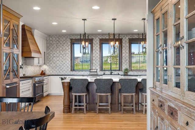 200 Miller Point Pl, Belgrade, MT 59714 - kitchen featuring high end stainless steel range oven, custom range hood, backsplash, light wood finished floors, and recessed lighting
