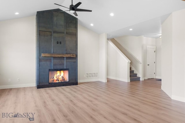 unfurnished living room with ceiling fan, light wood-type flooring, stairway, recessed lighting, and a large fireplace