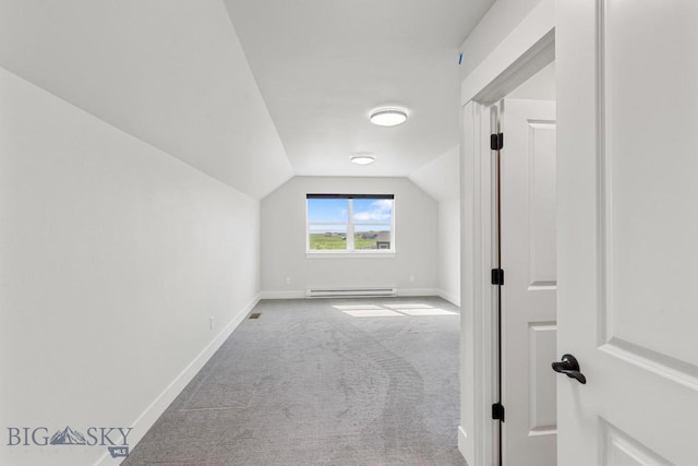 additional living space with a baseboard radiator, carpet floors, lofted ceiling, and baseboards