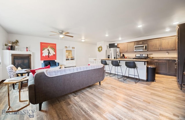 705 Halfpipe St Unit B, Belgrade, MT 59714 - living area featuring light wood-type flooring, a ceiling fan, a glass covered fireplace, and recessed lighting
