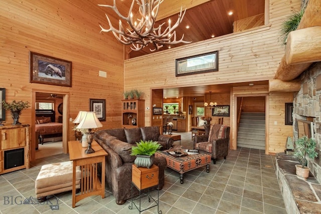 101 W Bridger Creek Rd, Big Timber, MT 59011 - living room with a towering ceiling, wooden walls, a chandelier, tile patterned floors, and wooden ceiling