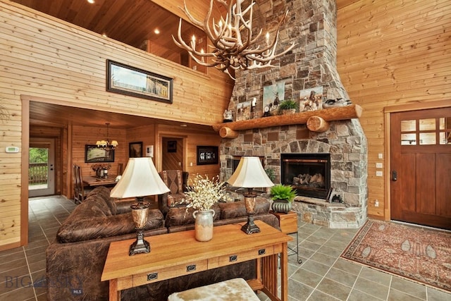 101 W Bridger Creek Rd, Big Timber, MT 59011 - tiled living area with a chandelier, a towering ceiling, wooden walls, a stone fireplace, and wooden ceiling