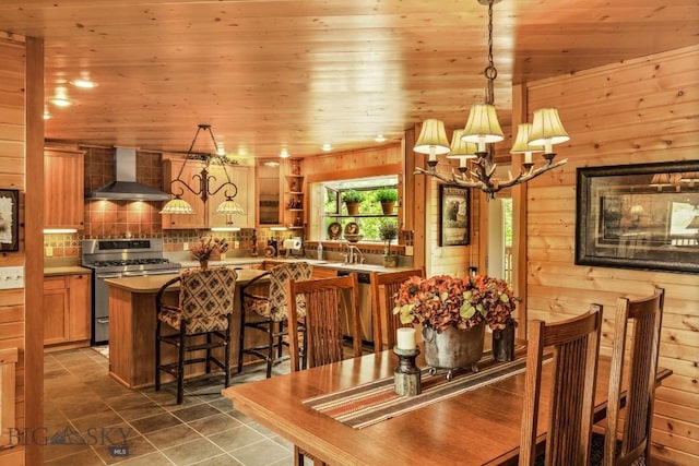 101 W Bridger Creek Rd, Big Timber, MT 59011 - dining room featuring a chandelier, wood ceiling, dark tile patterned floors, and wood walls