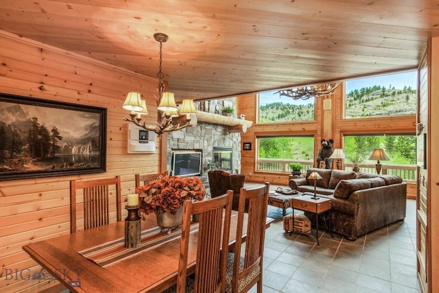101 W Bridger Creek Rd, Big Timber, MT 59011 - tiled dining space with a chandelier, wooden ceiling, wooden walls, and a stone fireplace