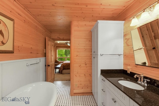 101 W Bridger Creek Rd, Big Timber, MT 59011 - ensuite bathroom with wood walls, a freestanding tub, vanity, wood ceiling, and tile patterned floors