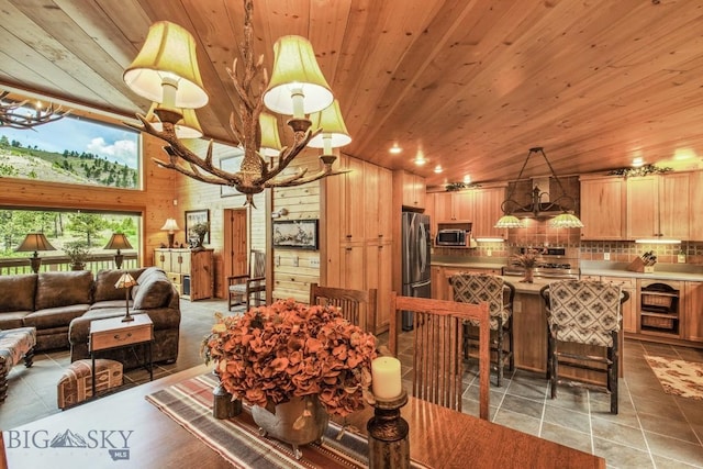 101 W Bridger Creek Rd, Big Timber, MT 59011 - dining space featuring wood ceiling, light tile patterned flooring, wood walls, and vaulted ceiling