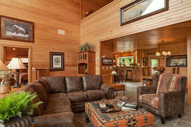 101 W Bridger Creek Rd, Big Timber, MT 59011 - living room with wooden walls, a high ceiling, a chandelier, and tile patterned flooring