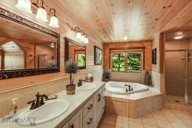 101 W Bridger Creek Rd, Big Timber, MT 59011 - bathroom featuring a shower stall, tile patterned floors, a garden tub, double vanity, and wooden walls