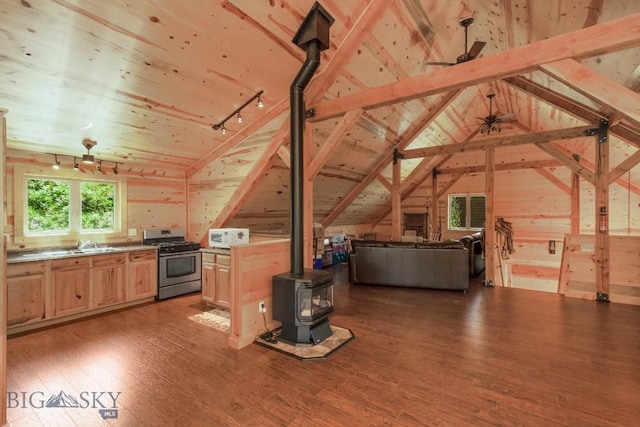 101 W Bridger Creek Rd, Big Timber, MT 59011 - kitchen with stainless steel range with gas cooktop, light brown cabinets, a wood stove, lofted ceiling, and light wood-style floors