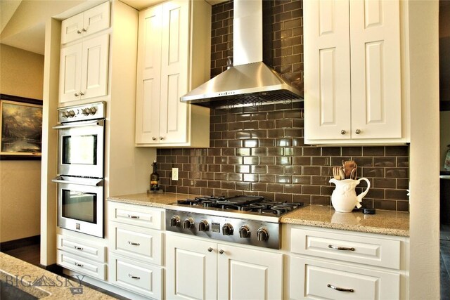 7 N Lewis And Clark Trl, Whitehall, MT 59759 - kitchen with wall chimney exhaust hood, stainless steel appliances, decorative backsplash, and white cabinets