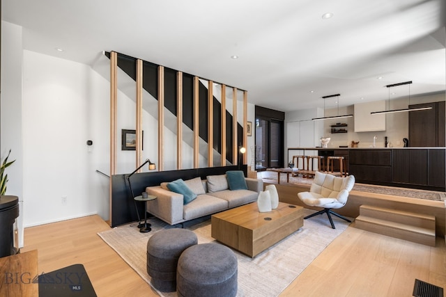 living area with light wood-style flooring, stairs, recessed lighting, and baseboards