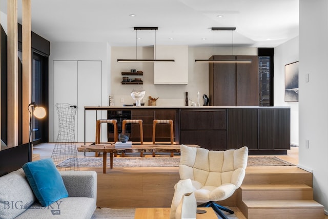 living room featuring light wood-style floors and bar