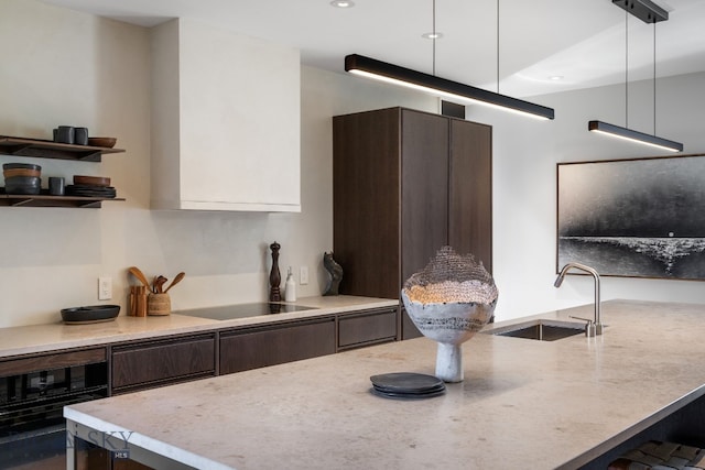 kitchen featuring a sink, black appliances, dark brown cabinets, modern cabinets, and recessed lighting