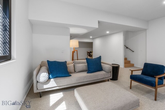 carpeted living area with stairway and recessed lighting