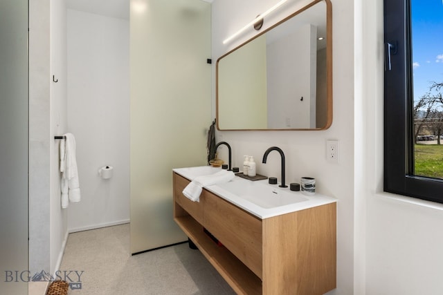 bathroom featuring double vanity and baseboards